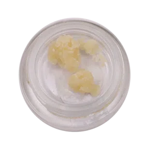 Top-down view of a small glass jar containing pale yellow waxy lumps inside.